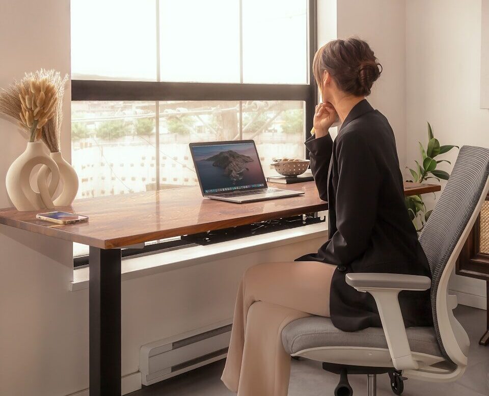 a woman sitting at a desk using a laptop computer